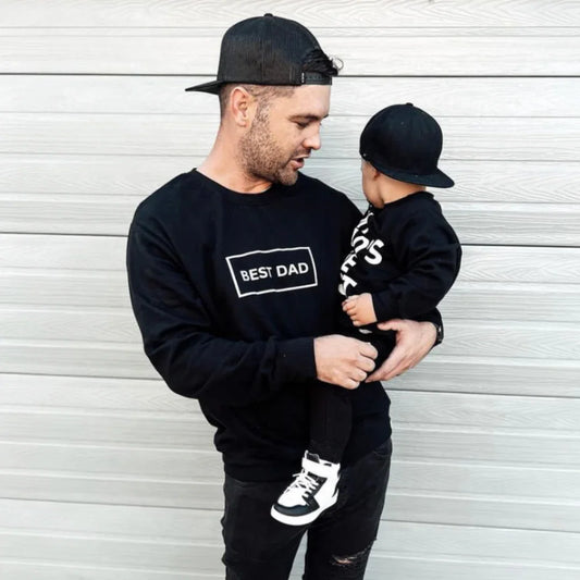 Dad and toddler in matching black 'Best Dad' sweatshirts and caps, stylish family outfits