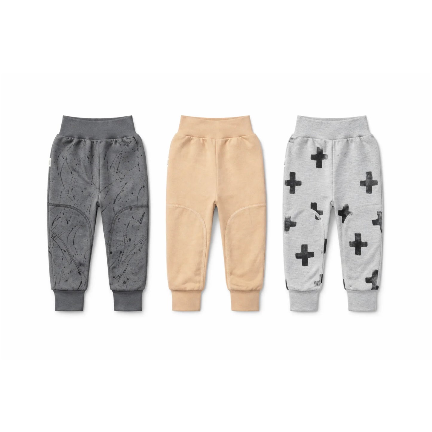 Kids' cozy joggers in gray, beige, and heather gray with plus sign and splatter prints, featuring knee patches.