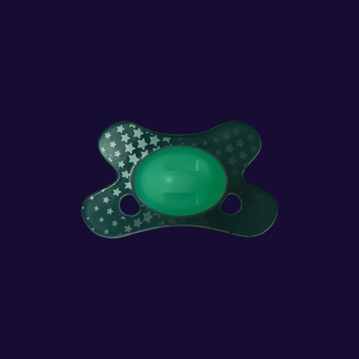 Green baby pacifier with white star pattern on dark background, ideal for infant comfort and soothing.