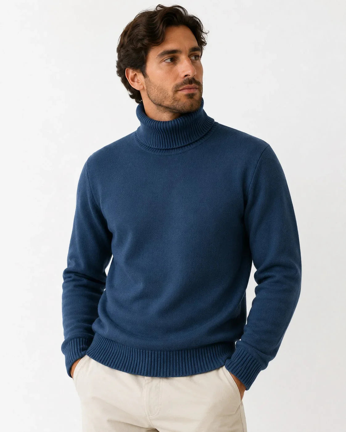 Man wearing navy blue turtleneck knit sweater with ribbed cuffs and hem, paired with beige pants